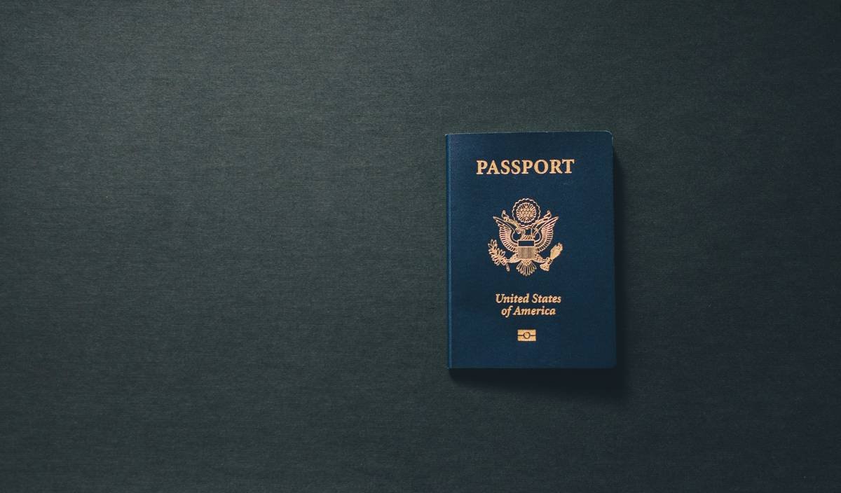 credit card travel insurance beneficiary form being filled out by traveler at airport lounge